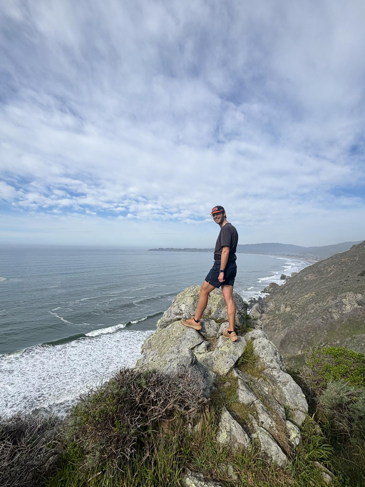 Standing on a rocky point high above a long beach on the Marin coastline