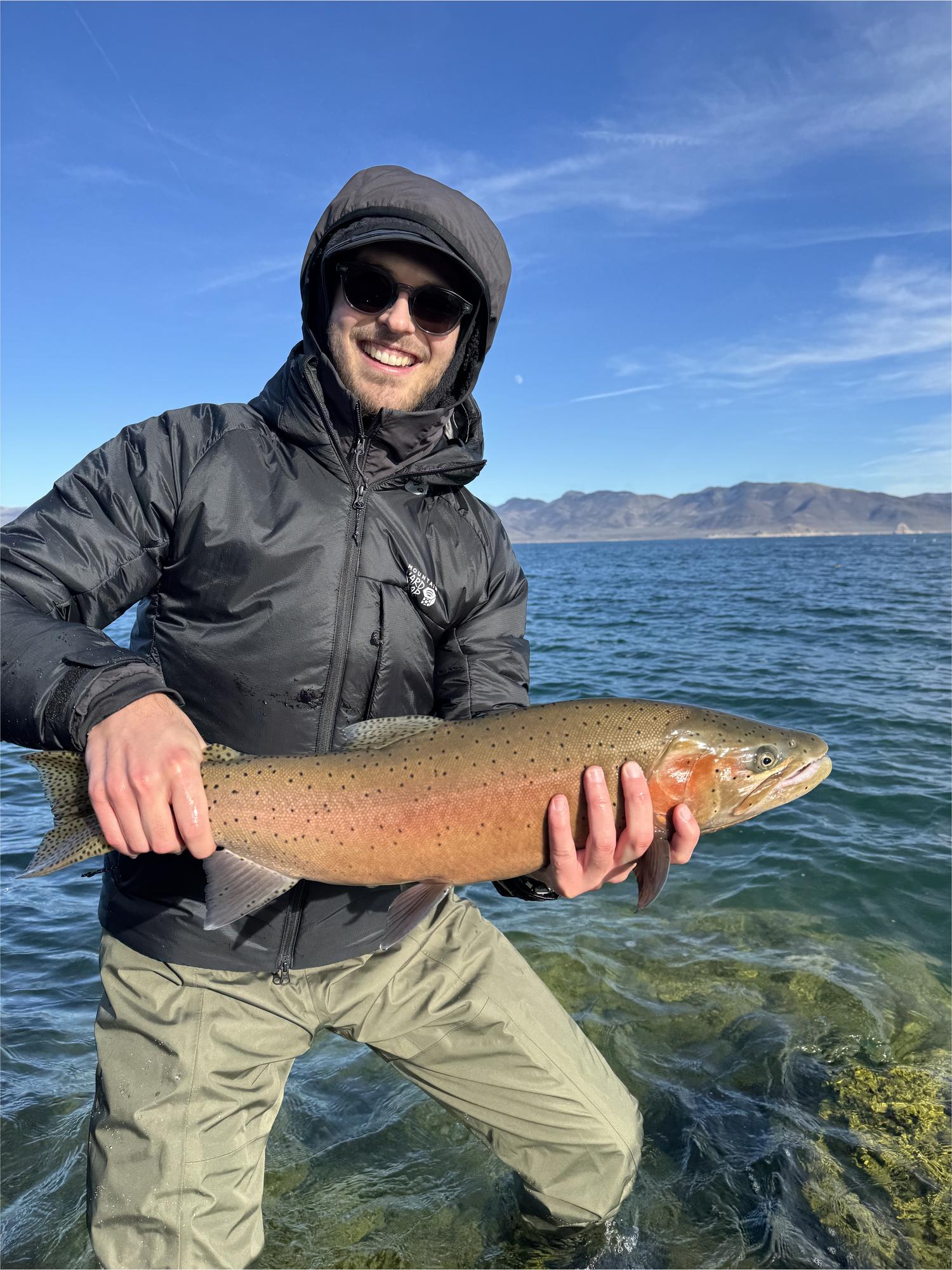 Jake Heller in waders holding a very large Lahontan cutthroat trout at Pyramid Lake, Nevada